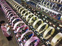 A worker is making silk products on a production line at a workshop of a silk production enterprise in Anqing, China, on January 26, 2024. (