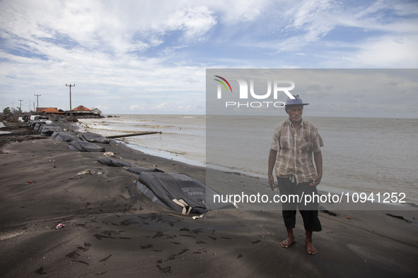 Carmat, 83, is posing for a photo near his house, which was destroyed by high waves in Cemarajaya Village, Karawang Regency, West Java Provi...