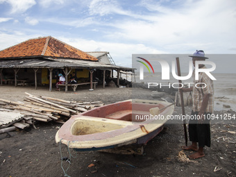 Carmat, 83, is posing for a photo near his house, which was destroyed by high waves in Cemarajaya Village, Karawang Regency, West Java Provi...