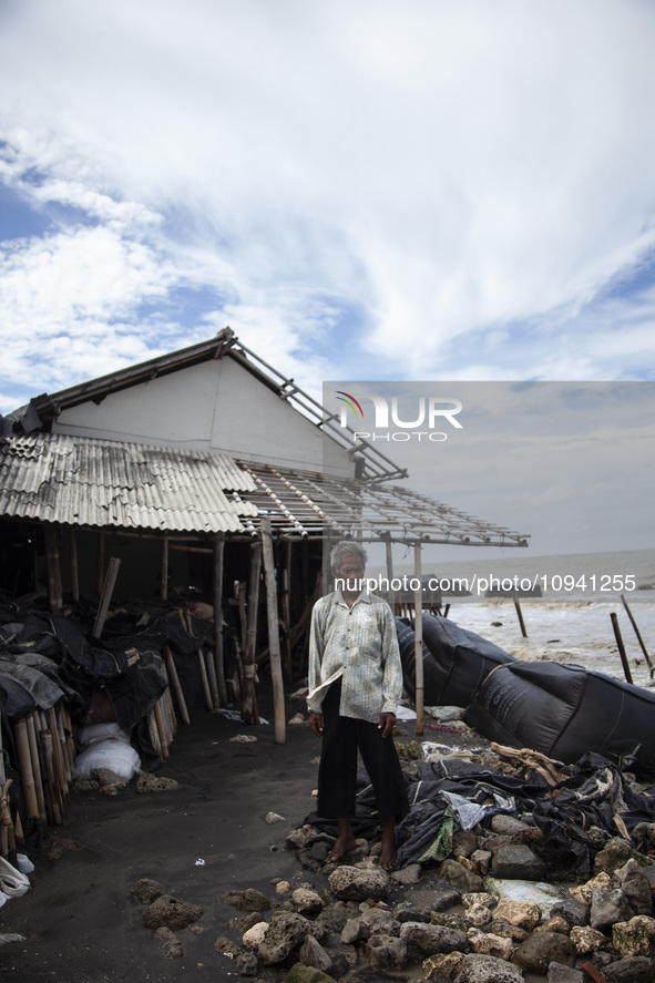 Carmat, 83, is posing for a photo near his house, which was destroyed by high waves in Cemarajaya Village, Karawang Regency, West Java Provi...