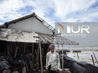 Carmat, 83, is posing for a photo near his house, which was destroyed by high waves in Cemarajaya Village, Karawang Regency, West Java Provi...