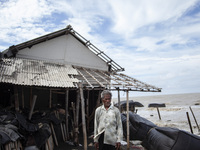 Carmat, 83, is posing for a photo near his house, which was destroyed by high waves in Cemarajaya Village, Karawang Regency, West Java Provi...