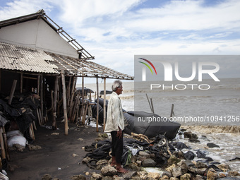 Carmat, 83, is staring out to sea near the remains of his house, which was destroyed by high waves in Cemarajaya Village, Karawang Regency,...