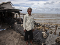 Carmat, 83, is posing for a photo near his house, which was destroyed by high waves in Cemarajaya Village, Karawang Regency, West Java Provi...