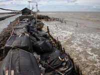 Giant sandbags that are being used as embankments to prevent erosion are being damaged after being hit by waves in Cemarajaya Village, Karaw...