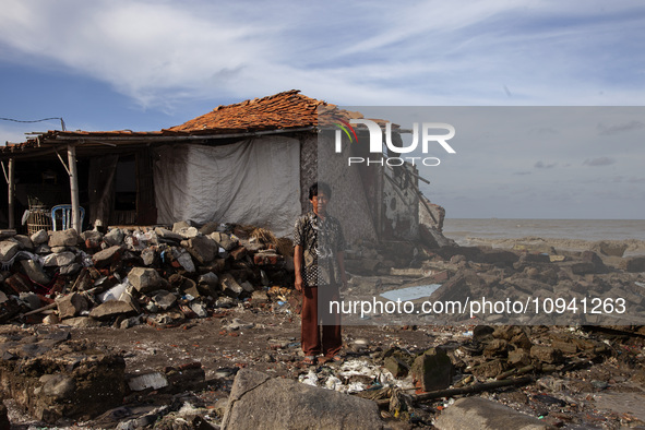 Jusiang Juwandi (56) is posing for a photo next to his house, which has been destroyed by high waves, in Cemarajaya Village, Karawang Regenc...