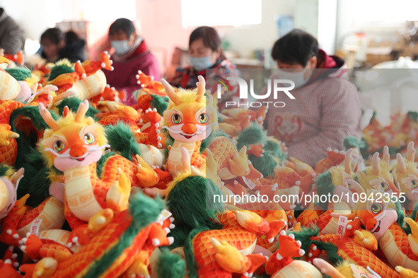 Workers are producing Chinese zodiac dragon toys at a toy company in Chengtou town, Ganyu district, Lianyungang city, Jiangsu province, East...