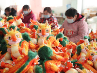 Workers are producing Chinese zodiac dragon toys at a toy company in Chengtou town, Ganyu district, Lianyungang city, Jiangsu province, East...