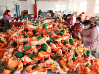 Workers are producing Chinese zodiac dragon toys at a toy company in Chengtou town, Ganyu district, Lianyungang city, Jiangsu province, East...