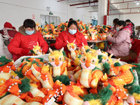 Workers are producing Chinese zodiac dragon toys at a toy company in Chengtou town, Ganyu district, Lianyungang city, Jiangsu province, East...