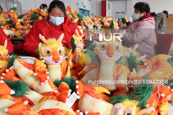 Workers are producing Chinese zodiac dragon toys at a toy company in Chengtou town, Ganyu district, Lianyungang city, Jiangsu province, East...