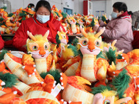 Workers are producing Chinese zodiac dragon toys at a toy company in Chengtou town, Ganyu district, Lianyungang city, Jiangsu province, East...