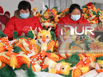 Workers are producing Chinese zodiac dragon toys at a toy company in Chengtou town, Ganyu district, Lianyungang city, Jiangsu province, East...