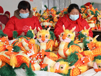 Workers are producing Chinese zodiac dragon toys at a toy company in Chengtou town, Ganyu district, Lianyungang city, Jiangsu province, East...