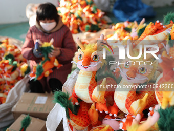 Workers are producing Chinese zodiac dragon toys at a toy company in Chengtou town, Ganyu district, Lianyungang city, Jiangsu province, East...