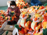 Workers are producing Chinese zodiac dragon toys at a toy company in Chengtou town, Ganyu district, Lianyungang city, Jiangsu province, East...