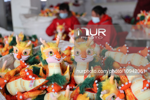 Workers are producing Chinese zodiac dragon toys at a toy company in Chengtou town, Ganyu district, Lianyungang city, Jiangsu province, East...