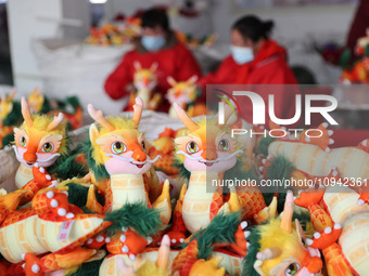 Workers are producing Chinese zodiac dragon toys at a toy company in Chengtou town, Ganyu district, Lianyungang city, Jiangsu province, East...