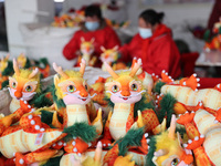 Workers are producing Chinese zodiac dragon toys at a toy company in Chengtou town, Ganyu district, Lianyungang city, Jiangsu province, East...