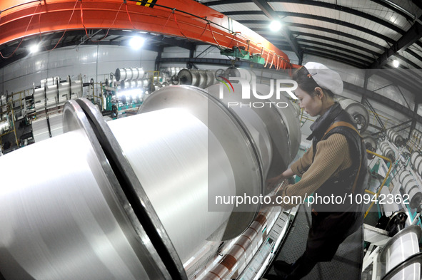 A worker is working on the production line of a warp knitting workshop at Yingyou Blanket Company in Lianyungang, China, on January 27, 2024...