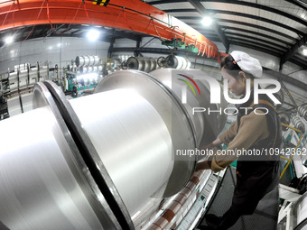 A worker is working on the production line of a warp knitting workshop at Yingyou Blanket Company in Lianyungang, China, on January 27, 2024...