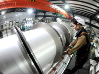 A worker is working on the production line of a warp knitting workshop at Yingyou Blanket Company in Lianyungang, China, on January 27, 2024...