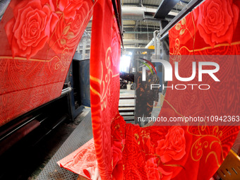 A worker is working on the production line of a warp knitting workshop at Yingyou Blanket Company in Lianyungang, China, on January 27, 2024...