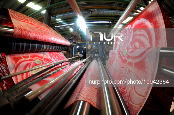 A worker is working on the production line of a warp knitting workshop at Yingyou Blanket Company in Lianyungang, China, on January 27, 2024...