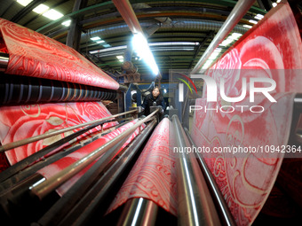 A worker is working on the production line of a warp knitting workshop at Yingyou Blanket Company in Lianyungang, China, on January 27, 2024...