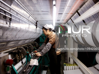 A worker is working on the production line of a warp knitting workshop at Yingyou Blanket Company in Lianyungang, China, on January 27, 2024...