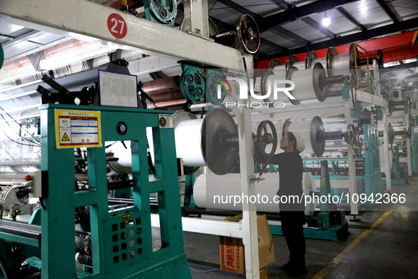 A worker is working on the production line of a warp knitting workshop at Yingyou Blanket Company in Lianyungang, China, on January 27, 2024...