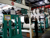 A worker is working on the production line of a warp knitting workshop at Yingyou Blanket Company in Lianyungang, China, on January 27, 2024...