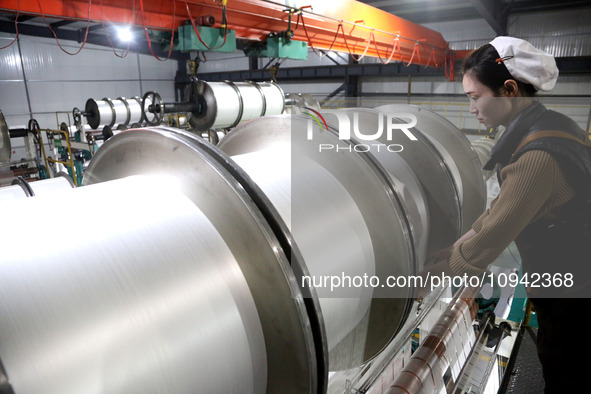 A worker is working on the production line of a warp knitting workshop at Yingyou Blanket Company in Lianyungang, China, on January 27, 2024...