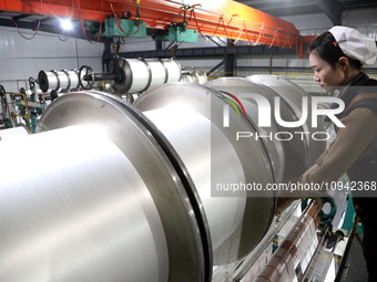 A worker is working on the production line of a warp knitting workshop at Yingyou Blanket Company in Lianyungang, China, on January 27, 2024...