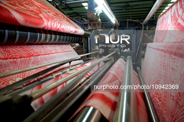 A worker is working on the production line of a warp knitting workshop at Yingyou Blanket Company in Lianyungang, China, on January 27, 2024...