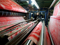 A worker is working on the production line of a warp knitting workshop at Yingyou Blanket Company in Lianyungang, China, on January 27, 2024...