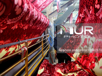 A worker is working on the production line of a warp knitting workshop at Yingyou Blanket Company in Lianyungang, China, on January 27, 2024...