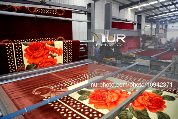 A worker is working on the production line of a warp knitting workshop at Yingyou Blanket Company in Lianyungang, China, on January 27, 2024...