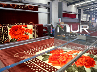 A worker is working on the production line of a warp knitting workshop at Yingyou Blanket Company in Lianyungang, China, on January 27, 2024...