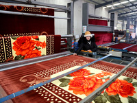 A worker is working on the production line of a warp knitting workshop at Yingyou Blanket Company in Lianyungang, China, on January 27, 2024...