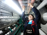 A worker is working on the production line of a warp knitting workshop at Yingyou Blanket Company in Lianyungang, China, on January 27, 2024...