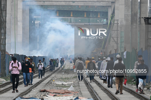 People Make Their Move As A Garbage Fire Creates Toxic Smoke Beside A Road In Dhaka, Bangladesh, On January 31, 2024. Dhaka City's Air Was C...