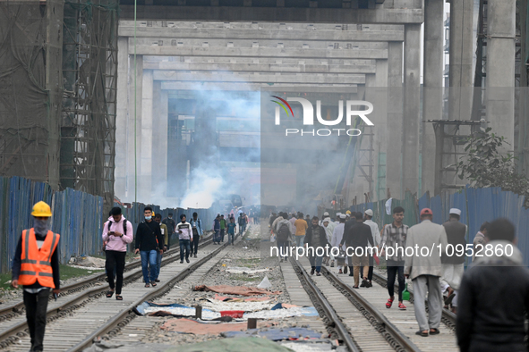 People move as a garbage fire produces toxic smoke next to a road in Dhaka, Bangladesh, on 31 January 2024. The air in Dhaka city has been c...