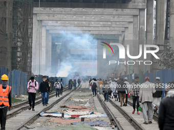 People move as a garbage fire produces toxic smoke next to a road in Dhaka, Bangladesh, on 31 January 2024. The air in Dhaka city has been c...