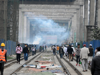 People move as a garbage fire produces toxic smoke next to a road in Dhaka, Bangladesh, on 31 January 2024. The air in Dhaka city has been c...