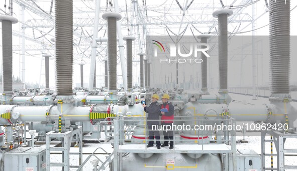 Power workers are carrying out a post-snow inspection of power supply equipment at a 500-kilovolt substation in Meizhuang village, Chuzhou c...