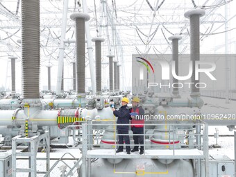 Power workers are carrying out a post-snow inspection of power supply equipment at a 500-kilovolt substation in Meizhuang village, Chuzhou c...