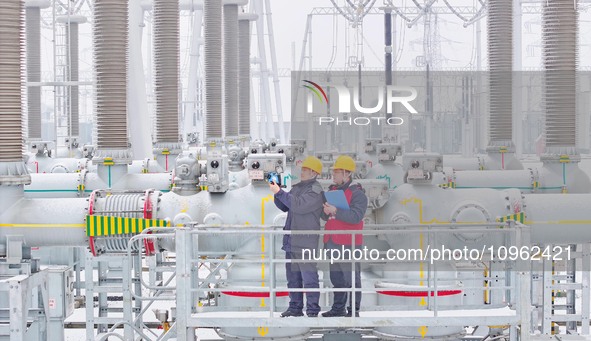 Power workers are carrying out a post-snow inspection of power supply equipment at a 500-kilovolt substation in Meizhuang village, Chuzhou c...