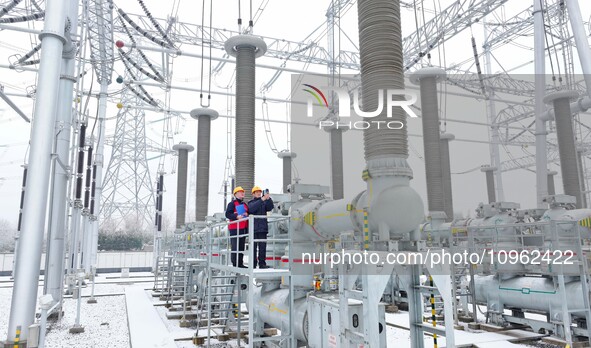 Power workers are carrying out a post-snow inspection of power supply equipment at a 500-kilovolt substation in Meizhuang village, Chuzhou c...