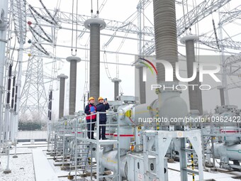 Power workers are carrying out a post-snow inspection of power supply equipment at a 500-kilovolt substation in Meizhuang village, Chuzhou c...